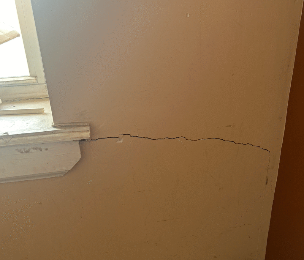 Vertical crack in interior drywall caused by foundation settlement